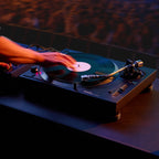 Technics SL-1210MKX in a club DJ booth with a DJ cueing a record
